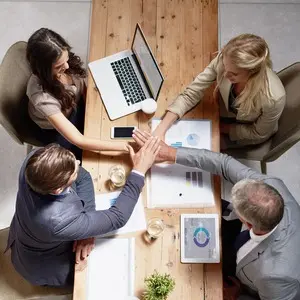 Diverse team happily high-fiving after completing a successful project
