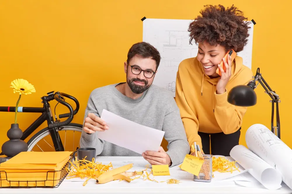 A man and a woman working happily at their desk